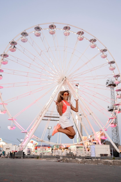 Foto gratuita ragazza piena del colpo che salta al luna park