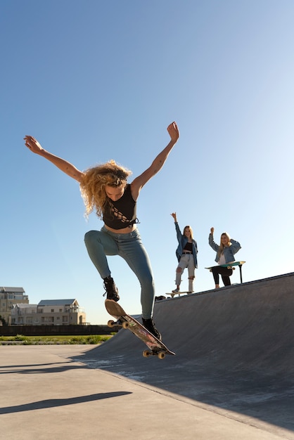スケートボードでジャンプするフルショットの女の子