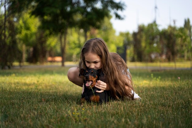 Full shot girl kissing dog on head