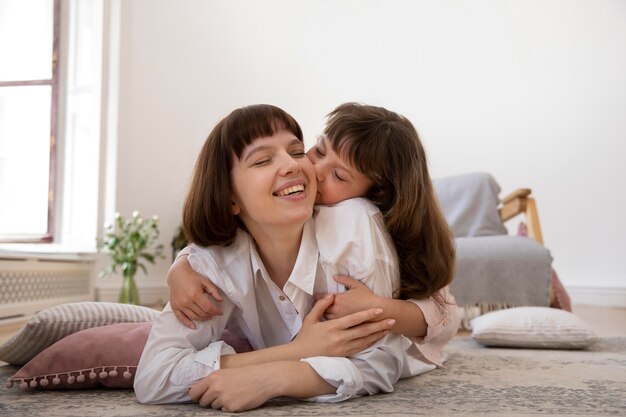 フルショットの女の子が母親にキス