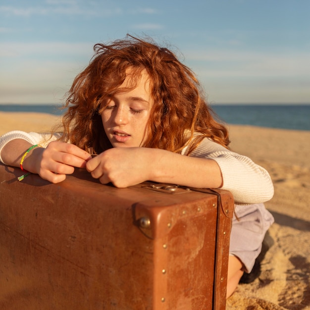 Free photo full shot girl laying on suitcase