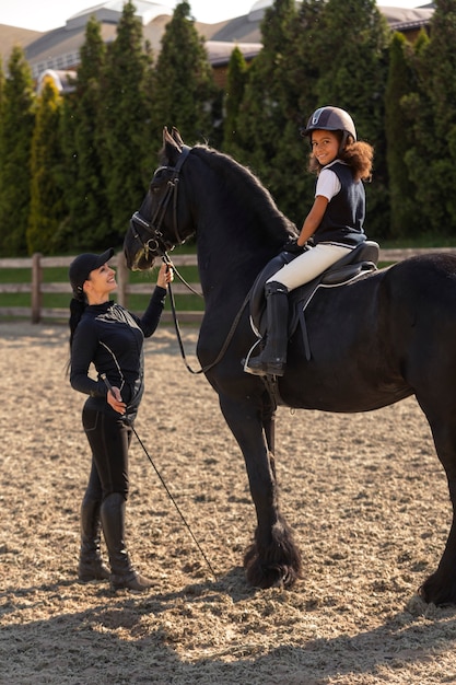 Full shot girl learning to ride horse