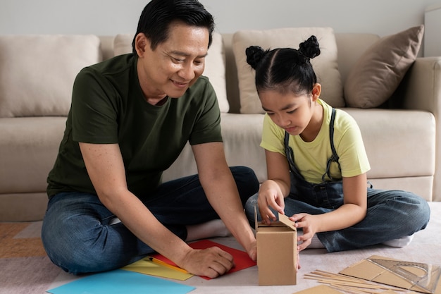 Full shot girl and man making small house