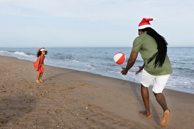 Full shot girl and man playing with ball