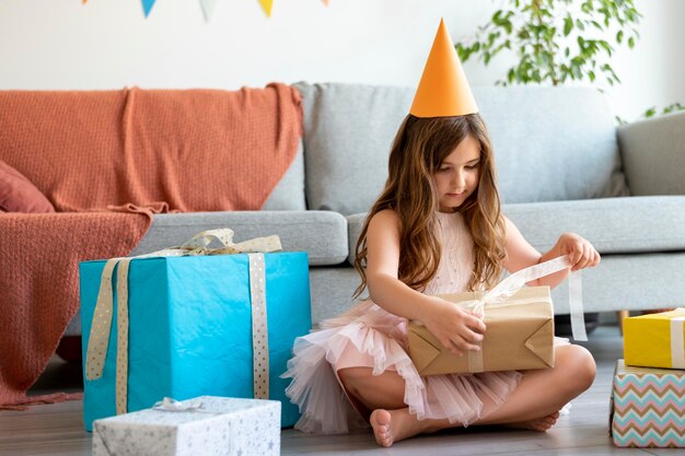 Full shot girl opening gift