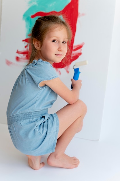full shot girl painting on canvas