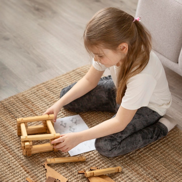 Full shot girl playing on floor