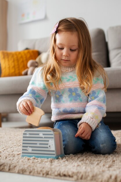 Full shot girl playing at home