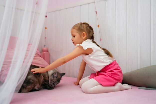 Free photo full shot girl playing with cat