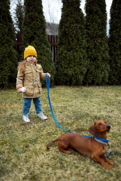 Full shot girl playing with dog outdoors
