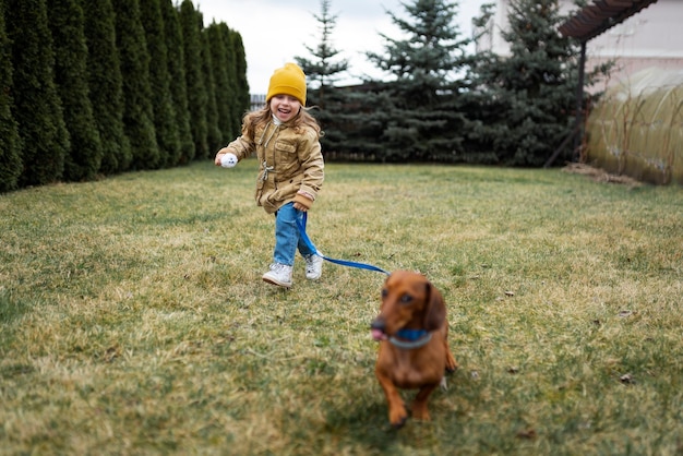 無料写真 屋外で犬と遊ぶフルショットの女の子
