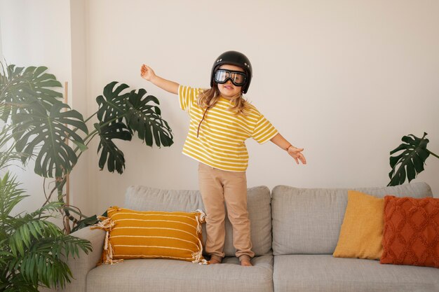 Full shot girl playing with flying goggles