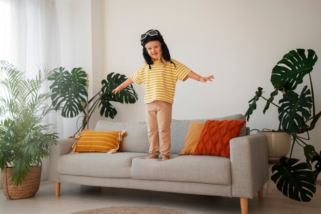 Full shot girl playing with flying goggles