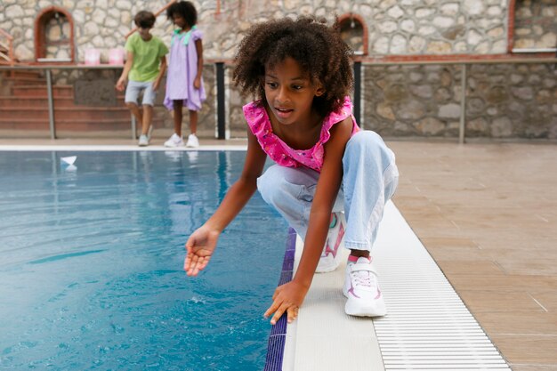 Девушка в полный рост играет с водой в бассейне