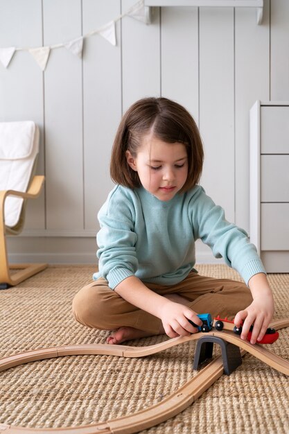 Full shot girl playing with toys on floor