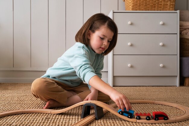 Full shot girl playing with train