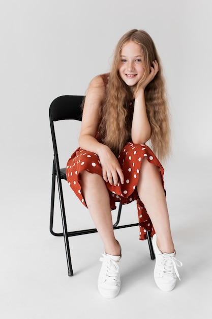 Full shot girl posing on chair