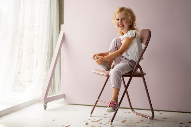 Full shot girl posing on chair