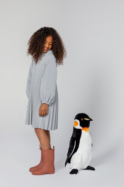 Free photo full shot girl posing with penguin