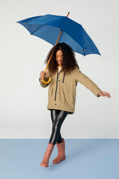 Full shot girl posing with umbrella