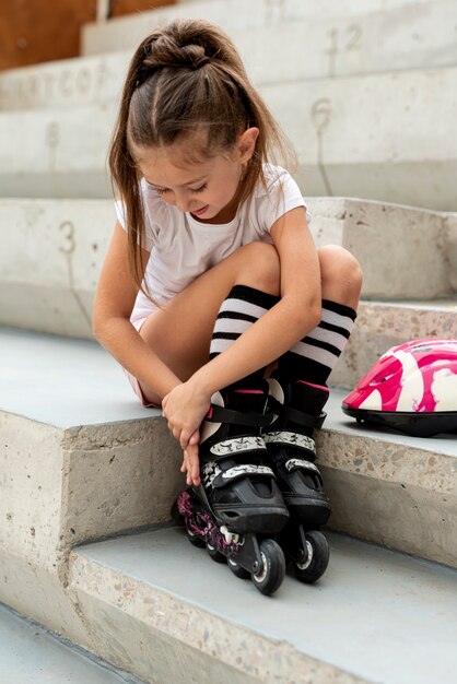 Full shot of girl putting on roller blades