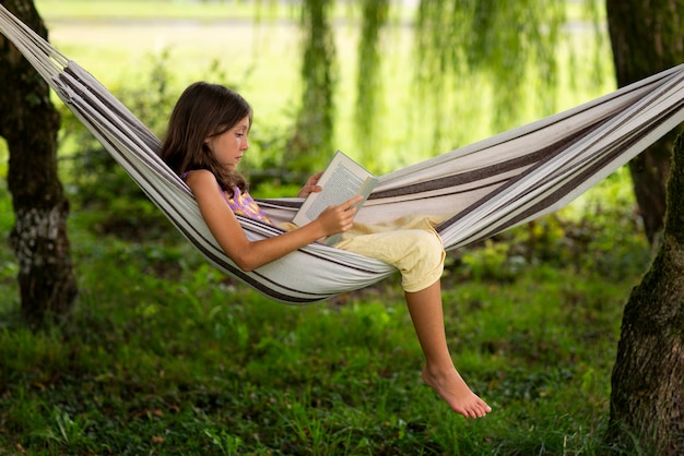 full shot girl reading in hammock