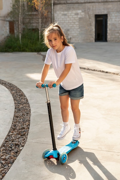 Full shot of girl riding scooter