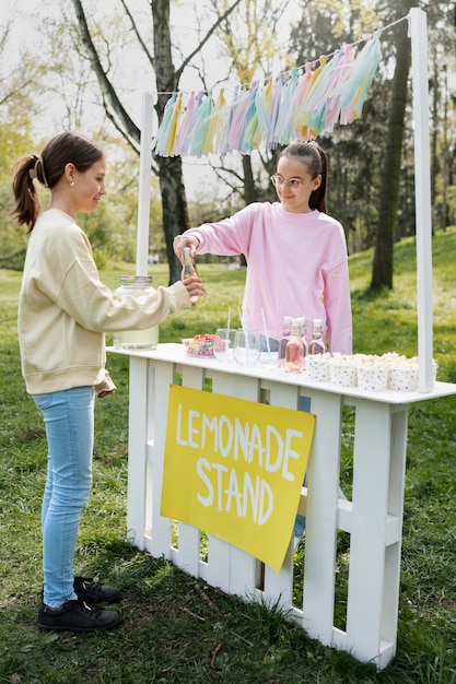 Девушка в полный рост продает лимонад