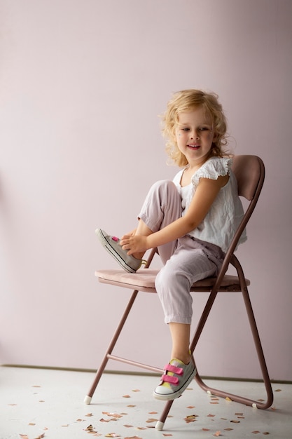 Free photo full shot girl sitting on chair