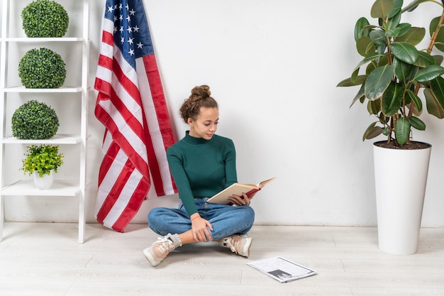 Full shot girl sitting on the floor and reading