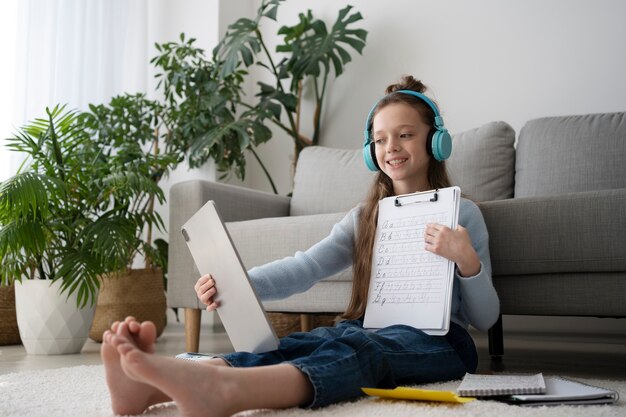 タブレットで床に座っているフルショットの女の子