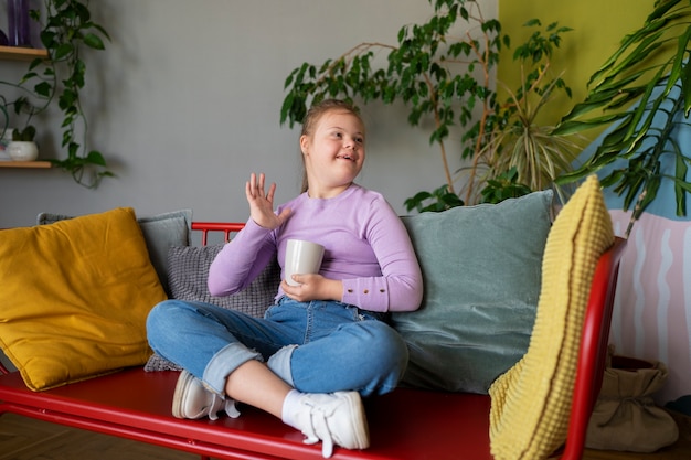 Full shot girl sitting indoors