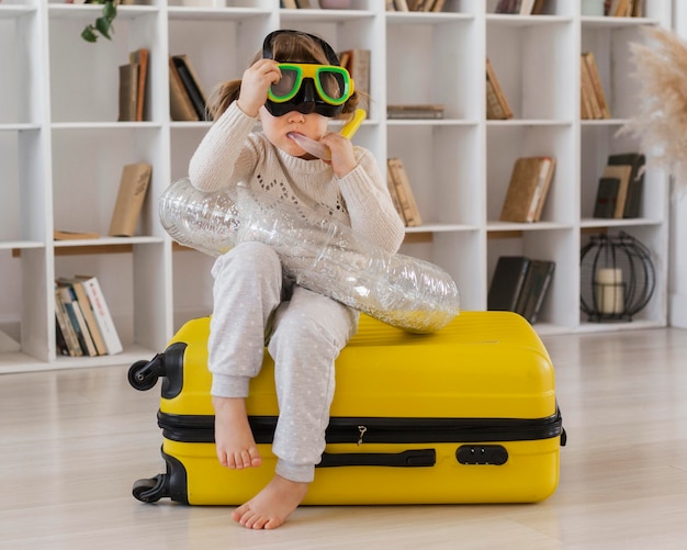 Free photo full shot girl sitting on luggage