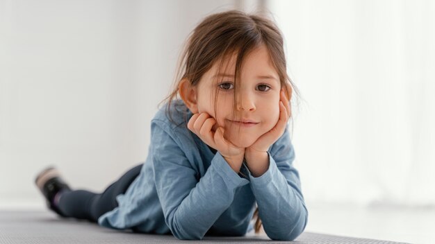 Full shot girl sitting on mat