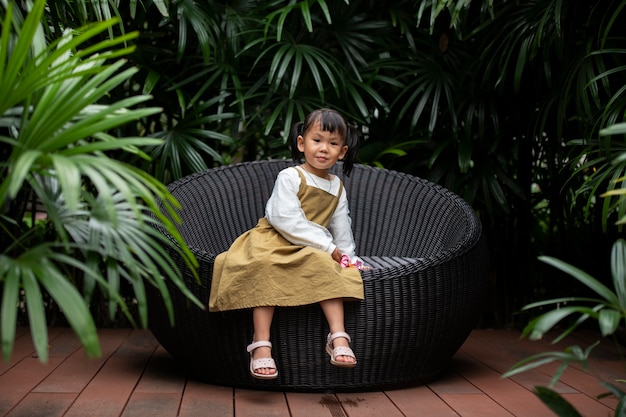 Full shot girl sitting outdoors