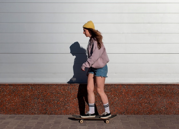 屋外でスケートをするフルショットの女の子
