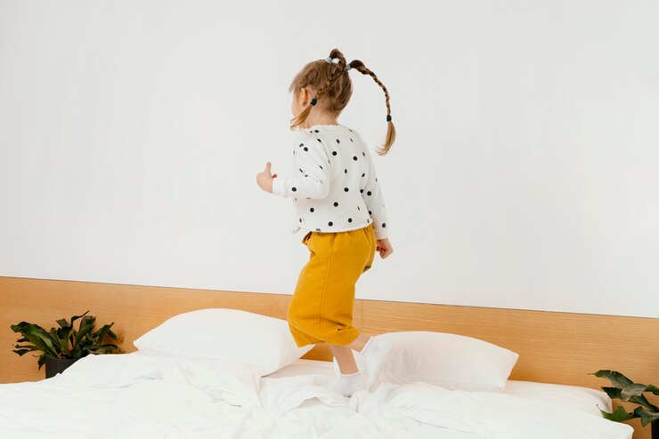 Free Photo full shot girl standing on bed at home