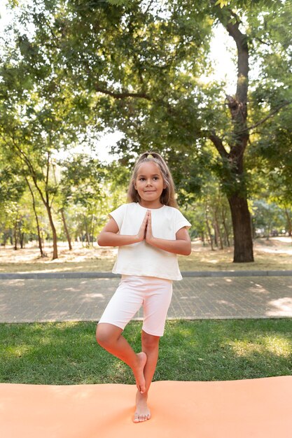 Full shot girl standing on one leg