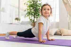 Free photo full shot girl training on yoga mat