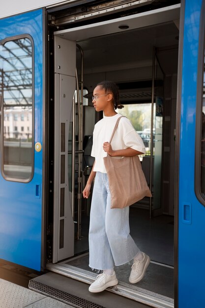 電車で旅行する女の子のフルショット