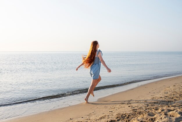 Full shot girl walking on beach