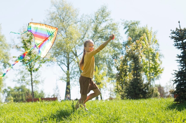 Free photo full shot girl with  colorful kite