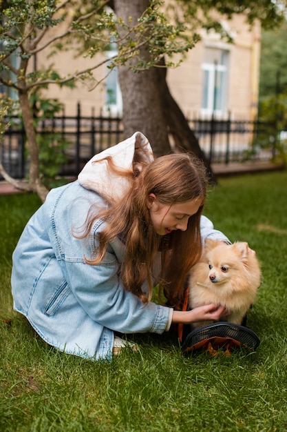 Foto gratuita ragazza del colpo pieno con il cane sveglio all'aperto