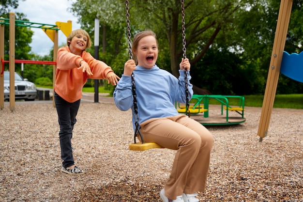 Free photo full shot girl with down syndrome on swing