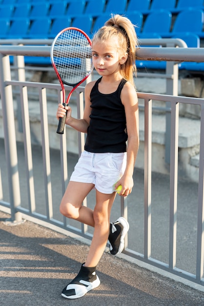 Full shot of girl with tennis racket and ball
