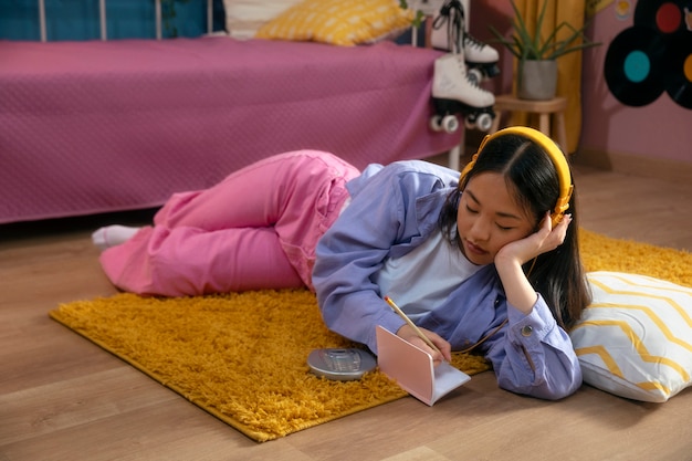 Ragazza del colpo pieno che scrive nel taccuino