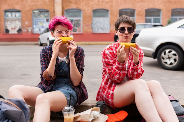 Full shot girls eating corn