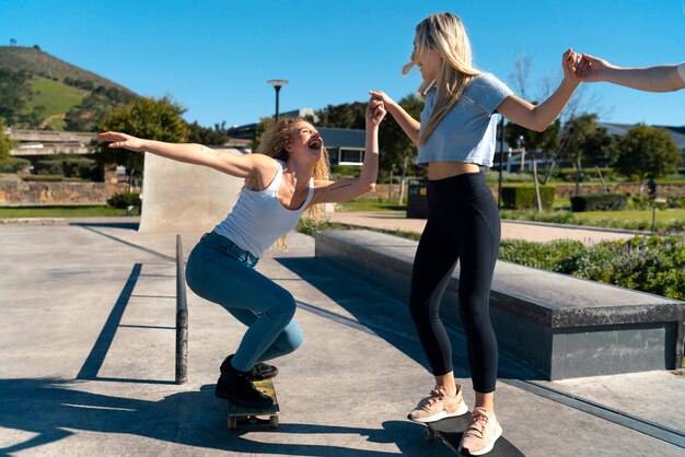 Девушки в полный рост развлекаются со скейтбордами