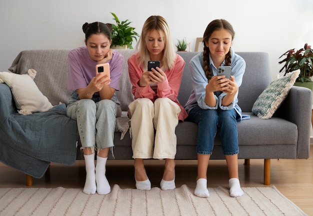 Full shot girls holding smartphones