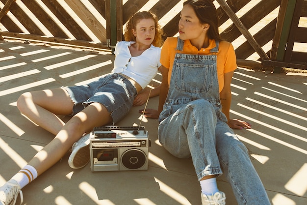 Free photo full shot girls with cassette player